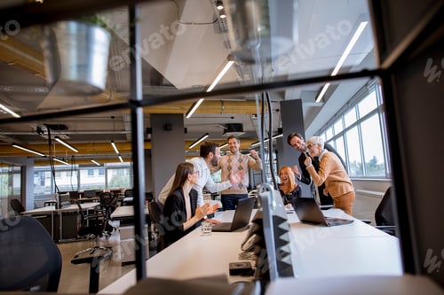 Preview: Happy young business people standing in the office and looking forward to success in the office