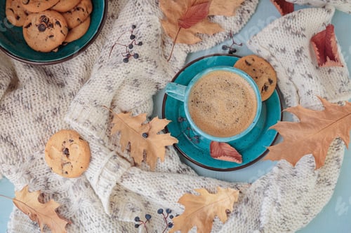 Preview: White knitted scarf, blue cup of coffee, cookies and dry yellow leaves