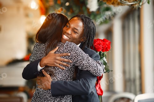Preview: Happy couple celebrating their engagement in a cafe and hugging tightly