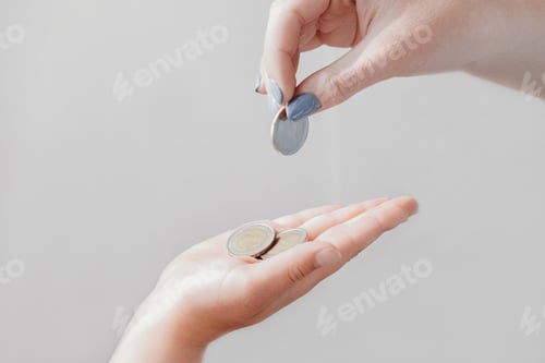 Preview: pocket money concept. woman's hand giving coins note to a child.