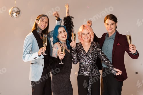 Preview: cheerful nonbinary people with champagne glasses and raised hands on beige background