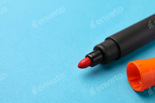 Preview: Bright orange marker on light blue background, closeup. Space for text