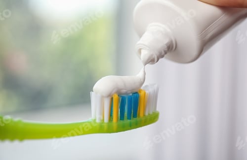 Preview: Applying paste on toothbrush against blurred background, closeup