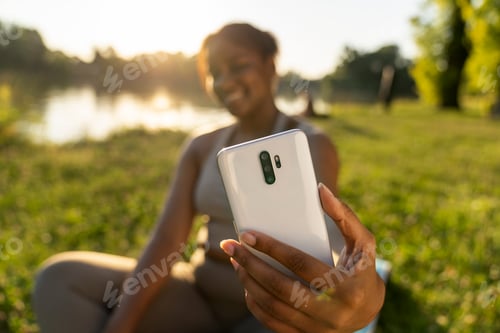 Preview: Plus size African-American woman doing selfie after training in the park