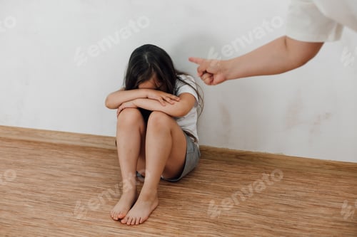 Preview: portrait of little afraid girl sitting with knees up, crossed arms. Man stretching hand fist to