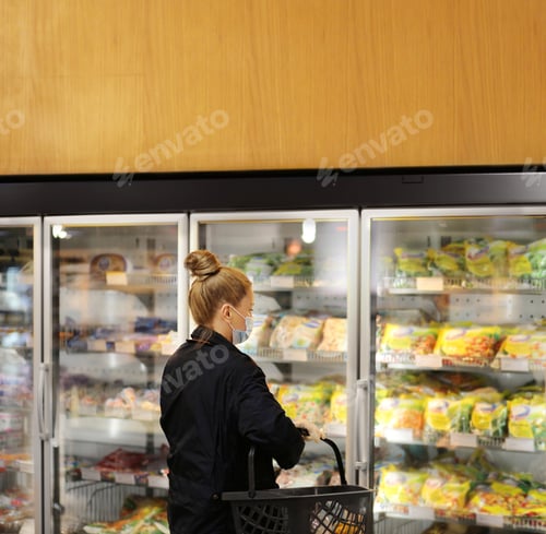 Preview: Woman Choosing Frozen Food From A Supermarket Freezer. Purchasing A Packet Of Meat At The