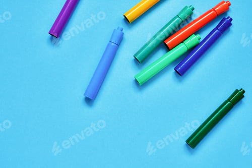 Preview: Colorful felt tip pens on blue backdrop. Top view, copy space. Back to school concept.