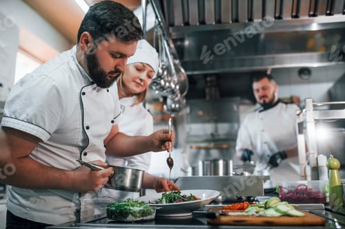 Preview: Three people. Making vegan salad. Professional chef preparing food in the kitchen