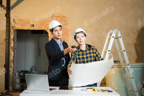 Preview: Asian architects and engineers planning construction project with blueprints, laptop, and teamwork