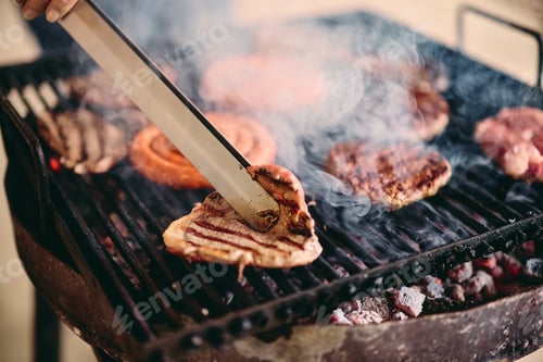 Vista previa: A male using a tool, making a barbecue, switching sides of the slice of meat, smoke being around.