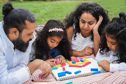 Preview: Happy indian family having fun playing with children outdoor at city park