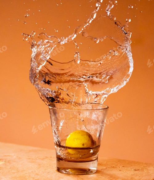 Preview: Closeup shot of a lemon falling into a glass of water