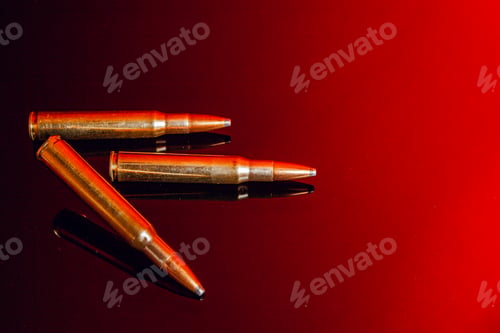 Preview: Rifle bullets or cartridges on black shiny background with red reflection