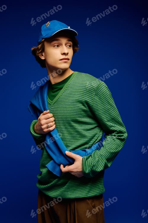 Preview: Young man showcases trendy fashion with vibrant colors in an artistic studio setting