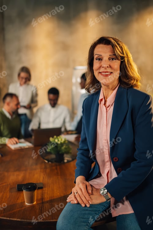 Preview: Happy mature executive posing at office on meeting of interracial team