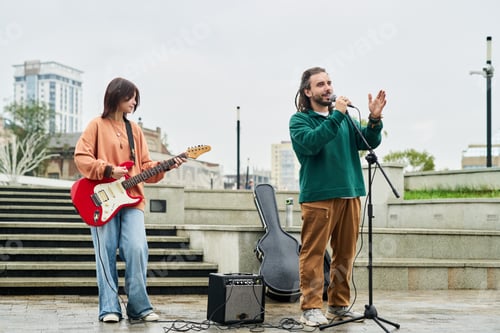 Preview: Young Caucasian Woman Playing Electric Guitar with Young Caucasian Man Singing