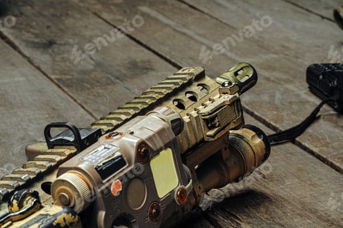 Preview: Close up photo of M16 rifle on wooden board