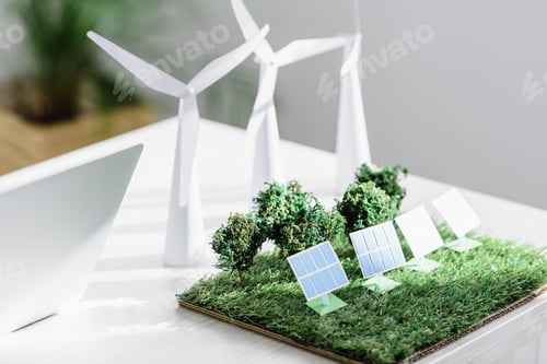 Preview: table with trees, windmills and solar panels models on grass in office