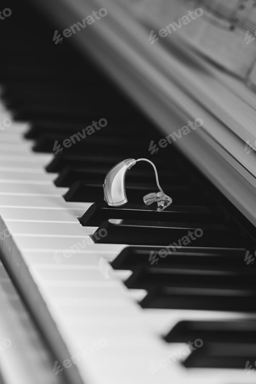 Preview: Hearing aid rests on piano keys, symbolizing the blend of music and sound accessibility