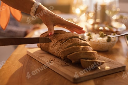 Preview: Close-up of woman cutting bread.