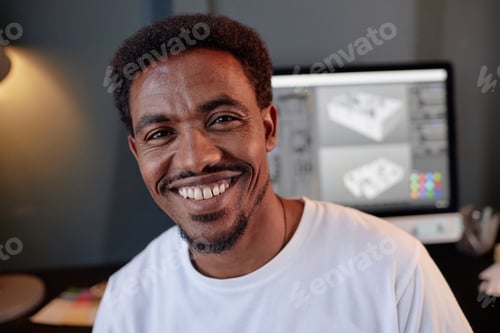 Preview: Smiling Man Working on 3D Design Software at Office