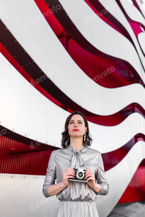 Preview: Attractive woman with a retro camera