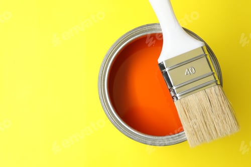 Preview: Can of orange paint and brush on yellow background, top view. Space for text