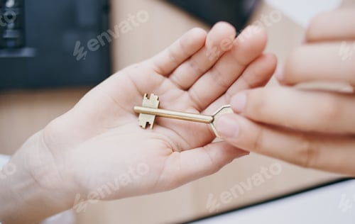 Preview: The key in the hand of a woman in the office at the table