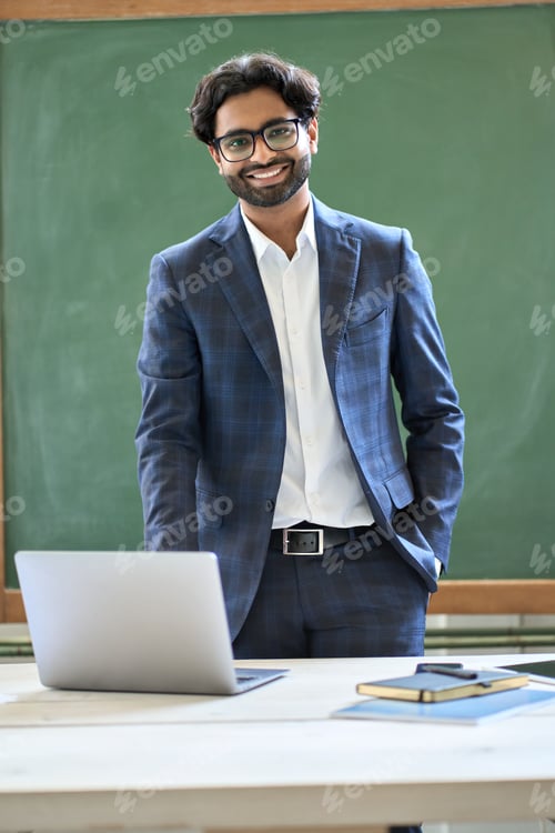 Preview: Smiling young indian business man wearing suit standing in office. Portrait