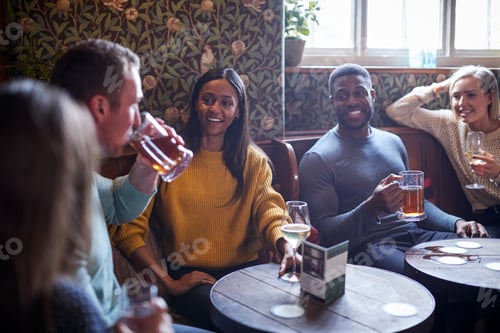 Preview: Group Of Friends Meeting For Lunchtime Drinks In Traditional English Pub
