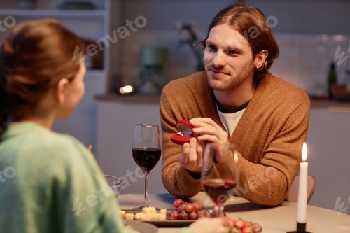 Preview: Young man holding open box with engagement ring