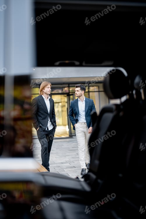 Preview: Two businessmen walk to the car from a building