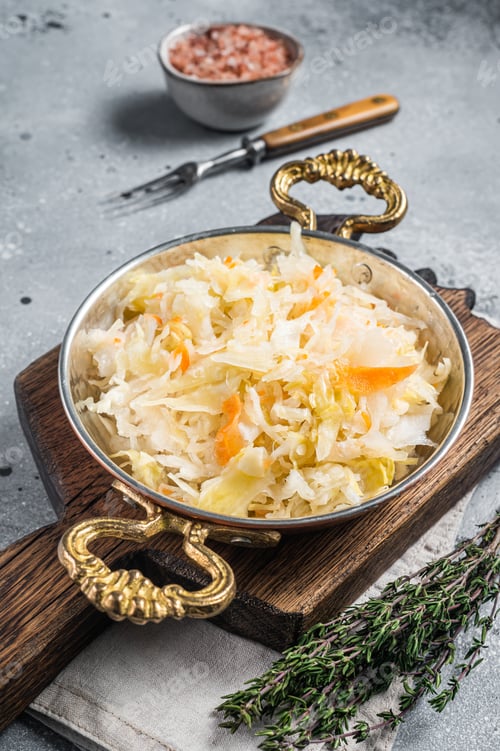 Preview: Homemade sauerkraut with black pepper and salt in a skillet. Gray background. Top view
