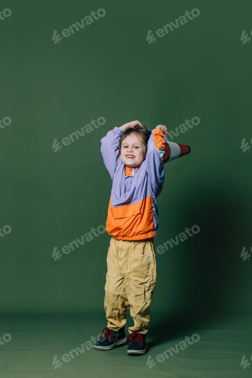 Preview: Stylish little boy with traffic cone on green background