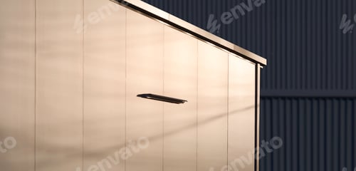 Preview: Sunlight reflection on aluminum composite wall of modern office near black steel warehouse building
