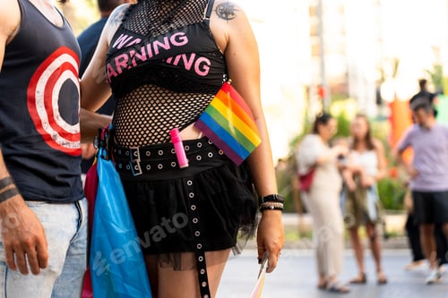 Preview: Woman showing rainbow flag at gay pride parade supporting lgbtq+ community