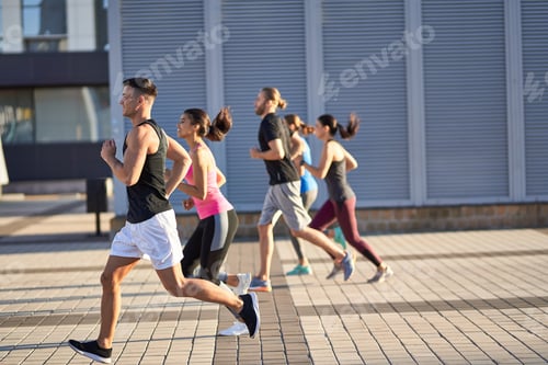 Preview: Men and women in sports clothing jogging outdoors