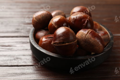 Preview: Roasted edible sweet chestnuts on wooden table, closeup