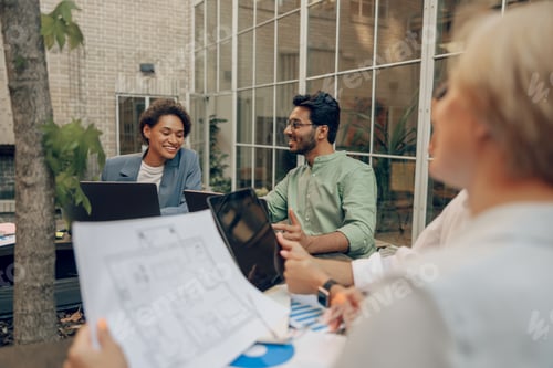 Preview: Group of professional business managers working with project documents in coworking terrace
