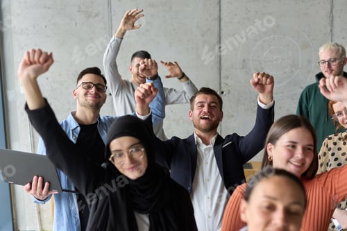 Preview: A diverse team of business professionals ecstatically celebrating their success in a modern office
