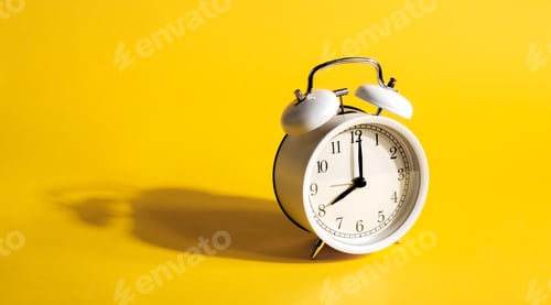 Preview: White alarm clock on a yellow background isolated, close-up.