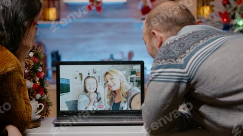 Preview: Festive couple talking to family on video call conference