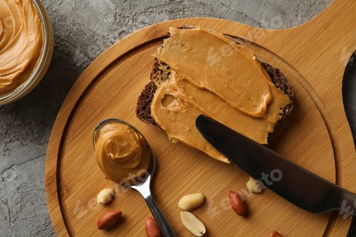 Preview: Concept of tasty breakfast with peanut and peanut butter on gray table
