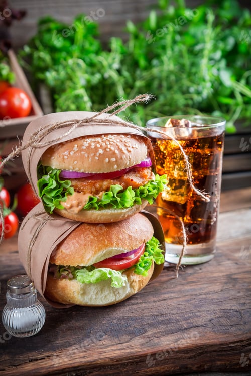 Preview: Takeaway tasty hamburger with cold drink on old wooden table