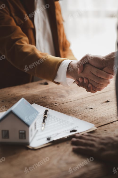 Preview: Real estate sales agents shake hands with customers of housing projects.