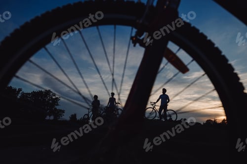 Preview: Cyclists through bicycle wheel.