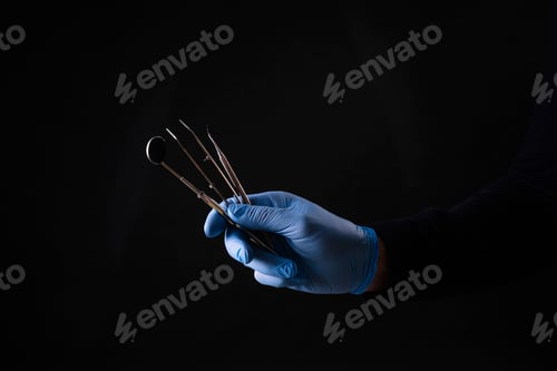 Preview: Detail of hand holding dental tools in dental clinic. Dental clinic.