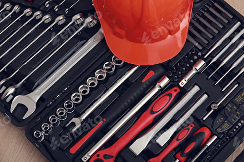 Preview: Toolbox, tools kit detail and orange protective helmet close up. instruments. set of tools. car