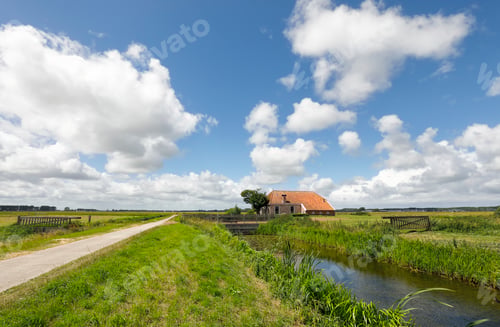 Preview: old farmhouse by river over blue sky
