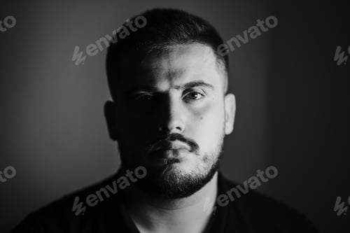 Preview: Grayscale portrait of a serious young Caucasian male with a shadow falling on his face